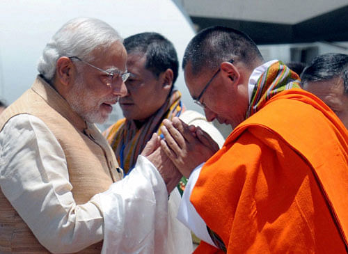 Prime Minister Narendra Modi being received by his Bhutanese counterpart Tshering Tobgay on his arrival at the Paro International Airport in Bhutan on Sunday.PTI Photo