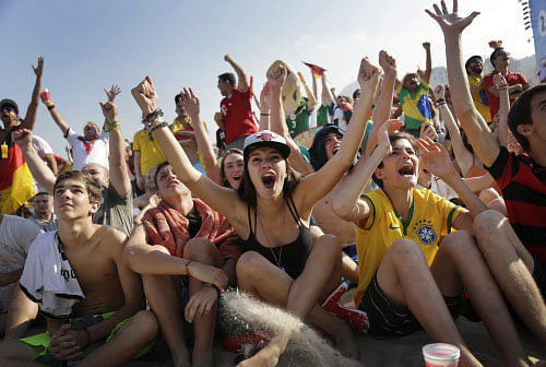 Soccer fans, many supporting Germany, raise their arms and cheer at the FIFA Fan Fest area on Copacabana beach, after Thomas Mueller scored Germany's fourth goal against Portugal on Monday, June 16, 2014 in Rio de Janeiro, Brazil, during Germany's World Cup soccer match with Portugal. AP photo