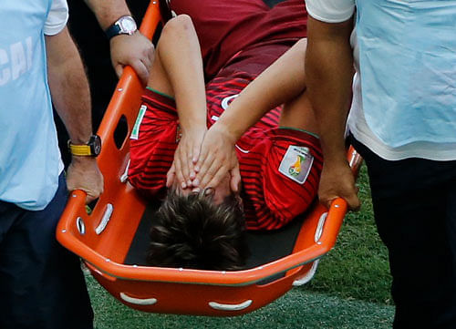 Portugal's Fabio Coentrao is carried off during the 2014 World Cup Group G soccer match between Germany and Portugal at the Fonte Nova arena in Salvador June 16, 2014. REUTERS