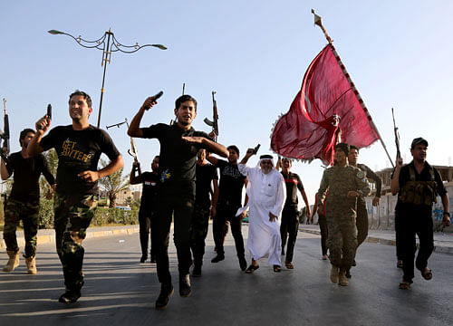 Iraqi Shiite tribal fighters raise their weapons and chant slogans against the al-Qaida-inspired Islamic State of Iraq and the Levant, after authorities urged Iraqis to help battle insurgents, in Baghdad's Sadr city. AP photo
