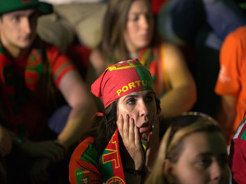 Fans react while watching on a TV screen, Portugal fall behind in the group G World Cup soccer match between Portugal and Germany. Two more Chinese men died due to lack of sleep as they spent their nights watching the FIFA World Cup, bringing the tally to three. AP photo