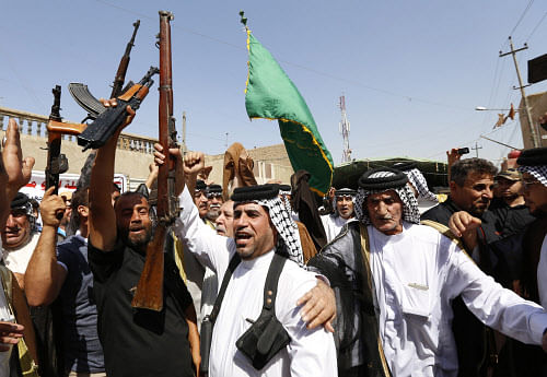 Iraqi Shi'ite men shout slogans in support for the call to arms by Grand Ayatollah Ali al-Sistani, who is the highest religious authority for Shi'ites in Iraq, in Baghdad's Sadr city, June 14, 2014. Grand Ayatollah Ali al-Sistani urged followers to take up arms against a full-blown Sunni militant insurgency to topple Shi'ite Prime Minister Nuri al-Maliki, escalating a conflict that threatens civil war and a possible break-up of the country. REUTERS