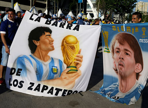 Argentinian fans hold banners with portraits of soccer legend Diego Armando Maradona, left, and Barcelona's soccer star Lionel Messi. AP photo