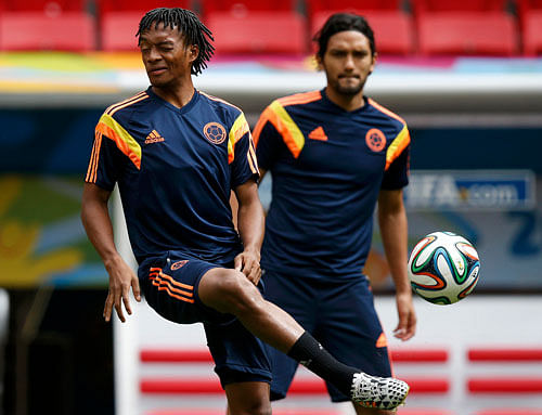 Garrincha National Stadium in Brasilia Colombia's player Juan Cuadrado (L) controls the ball during a team training session at the Mane Garrincha National Stadium in Brasilia, June 18, 2014. REUTERS