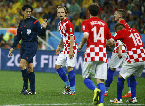 Referee Yuichi Nishimura of Japan (L) gestures to Croatia's national soccer players during their 2014 World Cup opening match against Brazil at the Corinthians arena in Sao Paulo. Reuters photo