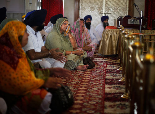 Family members pray for the safety of their relatives missing in Iraq, at a Sikh temple in New Delhi, India, Thursday, June 19, 2014. The Iraqi government has determined where 40 Indian construction workers abducted near Mosul are being held captive with workers of a few other nationalities, an official said Thursday. (AP Photo)