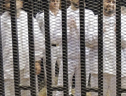 Muslim Brotherhood leader Mohamed El-Beltagy (R) stands with other senior figures in a cage in a courthouse on the first day of their trial in Cairo November 4, 2013. Reuters