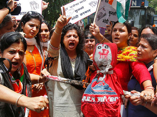 Activists of India's Congress party shout slogans as they hold an effigy representing Nihalchand Meghwal during a protest outside the headquarters of the ruling BJP in New Delhi. PTI