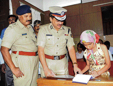 Vaibhavi writes the name of the suspect with her left hand in Mysore on Thursday. Police Commissioner M&#8200;A&#8200;Saleem and DCP&#8200;(crime and traffic)&#8200;M&#8200;M&#8200;Mahadevaiah look on. DH PHOTO