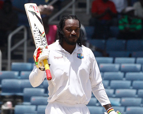 West Indies' opening batsman Chris Gayle raises his bat after scoring a half century during the third day of their first cricket Test match against New Zealand in Kingston, Jamaica, Tuesday, June 10, 2014. AP