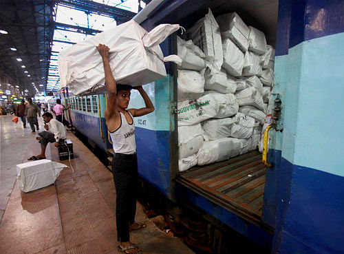 A labourer busy in loading goods in a train in Mumbai on Friday. The Central government on Friday approved a steep hike in railway passenger fare and freight rates. PTI Photo