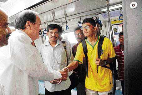 how's the ride, boy? Union Minister of Urban Development M Venkaiah Naidu interacts with a Metro commuter during his ride from Sampige Road to Rajajinagar on Friday. dh Photo