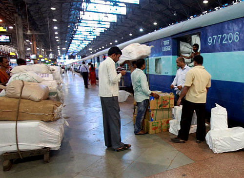 Railway labourers busy in loading goods in a train in Mumbai on Friday. The Central government on Friday approved a steep hike in railway passenger fare and freight rates. PTI Photo