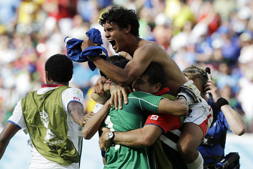 Costa Rica players celebrate with goalkeeper Keylor Navas (1) following the team's 1-0 victory over Italy during the group D World Cup soccer match between Italy and Costa Rica at the Arena Pernambuco in Recife, Brazil, Friday, June 20, 2014. (AP Photo)