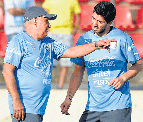 listen to me, my boy! Uruguay star Luis Suarez (right) with physio Walter Ferreira at a training session. Reuters
