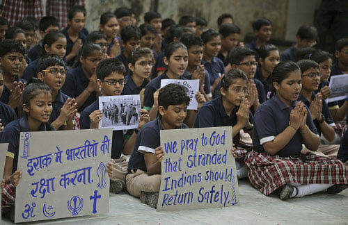 schoolchildren hold placards as they pray for safety of Indians stranded in Iraq, in Ahmedabad, AP photo