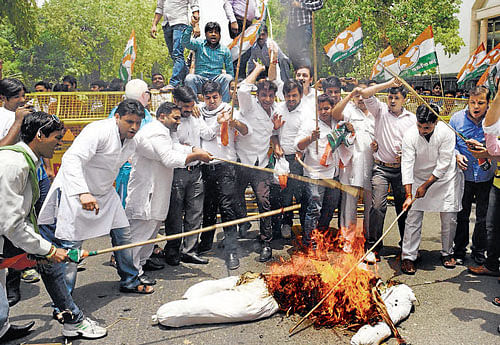 Youth Congress activists burn an effigy during a protest against proposed rail fare hike in New Delhi on Saturday. PTI photo