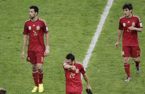 Spain's Sergio Busquets, Santi Cazorla and David Silva, from left, leave the pitch after the group B World Cup soccer match between Spain and Chile at the Maracana Stadium in Rio de Janeiro, Brazil, Wednesday, June 18, 2014. Spain was eliminated from the World Cup with a 2-0 loss to Chile. (AP Photo)