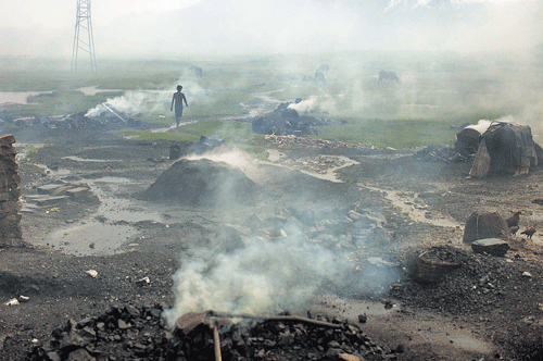 short supply: A man walks past heaps of burning coal to make it for domestic use such as for cooking purposes at Dhanbad district in Jharkhand. Restrictive supply policies helped push up India's coal imports to a record high of nearly 138 million tonnes in the last fiscal year. India sits on top of the world's fourth largest reserves of the fuel, but has become the third biggest coal importer after China and Japan, an estimate by the World Coal Association showed. REUTERS