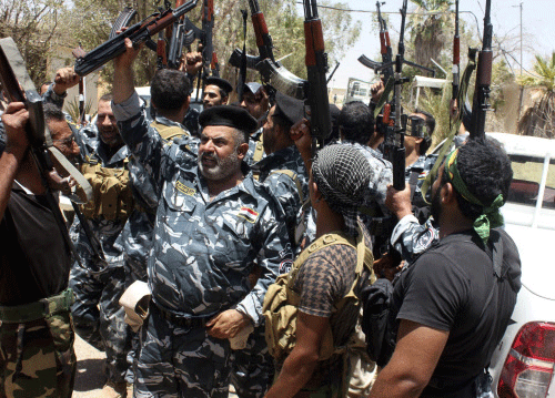 Members of the Iraqi security forces and volunteers, who have joined the security forces to fight against the predominantly Sunni militants from the radical Islamic State of Iraq and the Levant (ISIL), shout slogans on the outskirts of the town of Udaim in Diyala province, June 22, 2014. Reuters photo