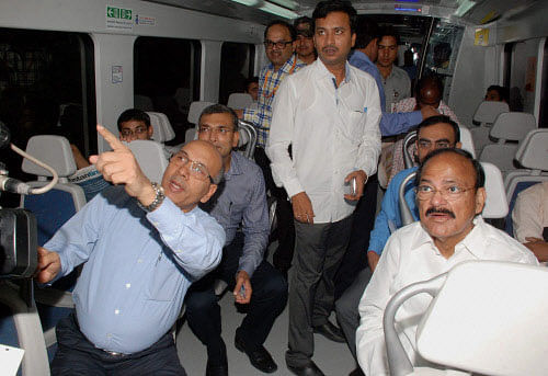 Union Urban Development Minister Venkaiah Naidu with DMRC Managing Director Mangu Singh riding a metro train in New Delhi on Monday. PTI Photo