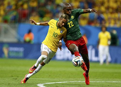 Brazil's Neymar fights for the ball with Cameroon's Allan Nyom during their 2014 World Cup Group A soccer match at the Brasilia national stadium in Brasilia June 23, 2014. REUTERS