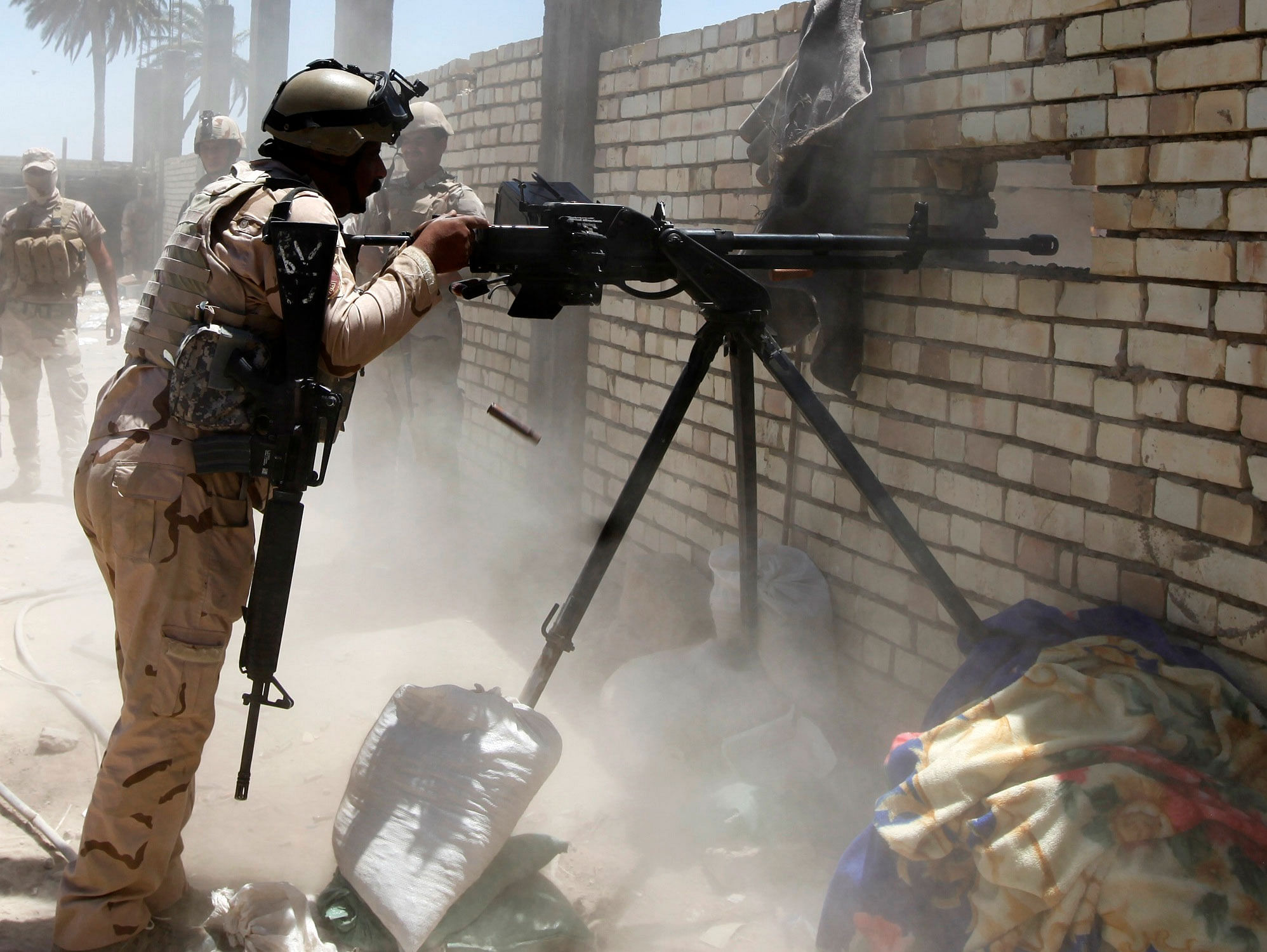 A member of the Iraqi security forces opens fire during clashes with the ISIL, west of Baghdad