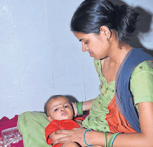 Manju holds her infant at the Chapra  hospital. She, as well as her grandparents, barely managed to escape the mishap.DH photo