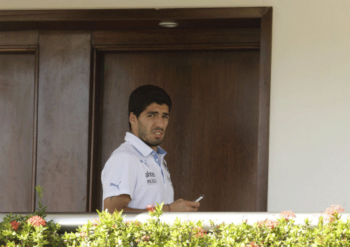 Uruguay's Luis Suarez uses his cell phone at a hotel in Natal, Brazil, Wednesday, June 25, 2014. AP photo