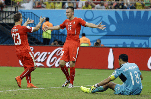 Switzerland's Xherdan Shaqiri, left, celebrates with teammate Josip Drmic, as Honduras' goalkeeper Noel Valladares sits, after scoring his side's third goal during the group E World Cup soccer match between Honduras and Switzerland at the Arena da Amazonia in Manaus, Brazil, Wednesday, June 25, 2014. AP Photo