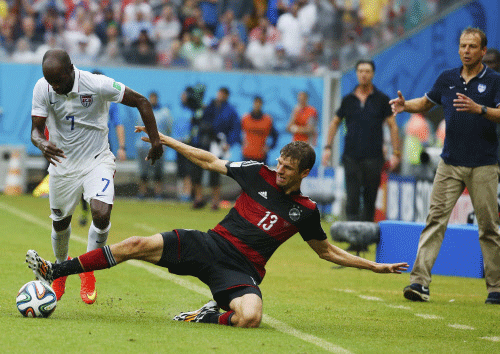 DaMarcus Beasley of the U.S. (L) fights for the ball with Germany's Thomas Mueller as U.S. coach Juergen Klinsmann (R) watches during their 2014 World Cup Group G soccer match at the Pernambuco arena in Recife June 26, 2014. Reuters photo