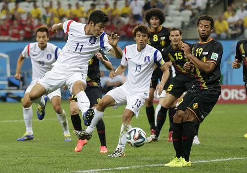 Belgium's Mousa Dembele, right, blocks a kick by South Korea's Lee Keun-ho, left, during the group H World Cup soccer match between South Korea and Belgium at the Itaquerao Stadium in Sao Paulo, Brazil, Thursday, June 26, 2014. AP photo