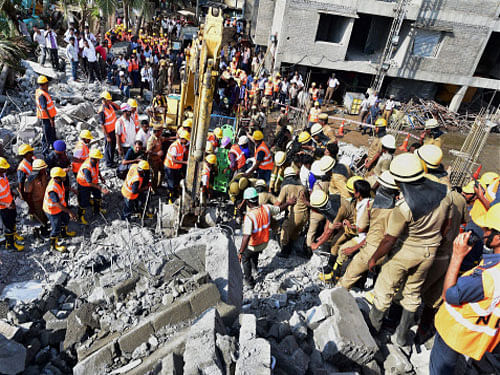 Rescue workers at the collapsed eleven-storey building near suburban Porur in Chennai. PTI Photo