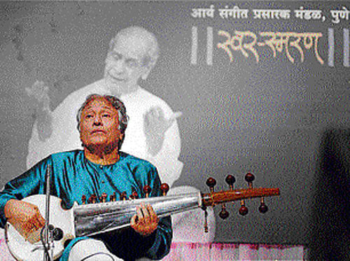 miles apart In a photo taken on Thursday, Ustad Amjad Ali Khan plays his sarod, which has now gone missing. PTI