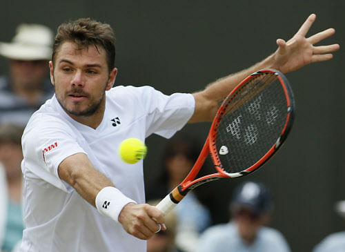 Stan Wawrinka of Switzerland plays a return to Denis Istomin of Uzbekistan during their men's singles match at the All England Lawn Tennis Championships in Wimbledon, London, Monday, June 30, 2014. (AP Photo)