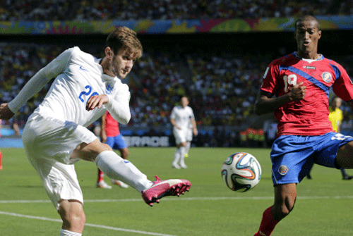 England's Adam Lallana kicks a cross as Costa Rica's Roy Miller defends during the group D World Cup soccer match between Costa Rica and England. AP photo