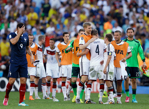 France's Olivier Giroud walks past celebrating German players after Germany defeated France 1-0 to advance to the semifinals during the World Cup quarterfinal soccer match at the Maracana Stadium in Rio de Janeiro, Brazil, Friday, July 4, 2014. (AP Photo)