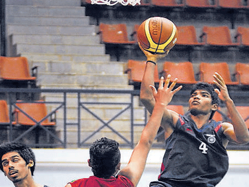 India's Akhilesh Kumar goes for a basket as Shadhin Khan  of Bangladesh tries to stop him. DH photo