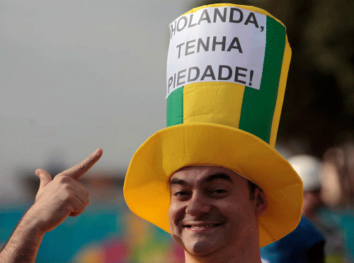 A Brazil soccer fan shows his hat with a sign written in Portuguese that reads 'Netherlands have mercy'. AP photo
