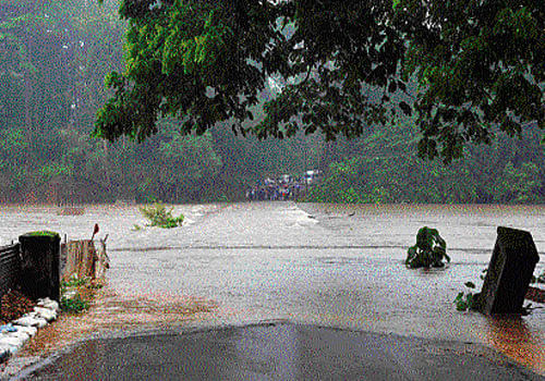 A view of Malavoor dam built across Gurpura river near Mangalore. (Right) The Kumaradhara bridge is inundated at Subrahmanya in Dakshina Kannada district on Sunday.