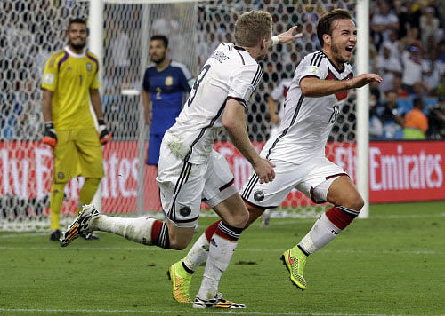 Germany's Mario Goetze, right, celebrates after scoring the opening goal during the World Cup final soccer match between Germany and Argentina at the Maracana Stadium in Rio de Janeiro, Brazil, Sunday, July 13, 2014. AP photo