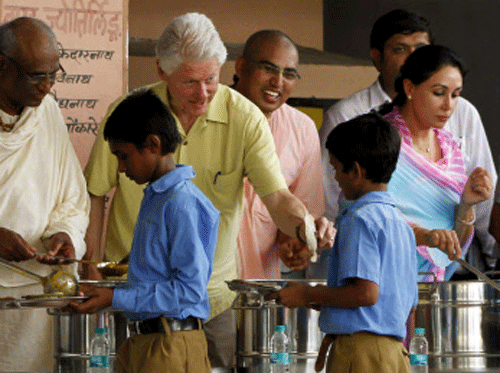 Former US President Bill Clinton today visited the kitchen run by an NGO which provides food to a large number of children at government schools as part of the mid-day meal scheme. PTI photo