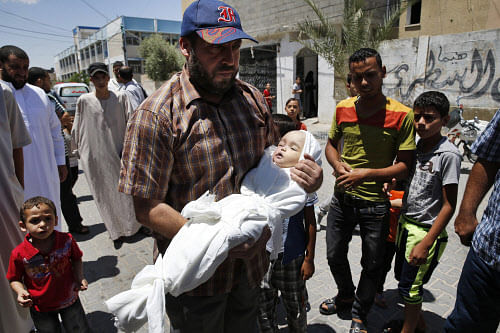 A relative carries five-month-old Lama al-Satari, who died of internal injuries during ongoing violence between Israel and Hamas in Gaza, to her family home during her funeral in Rafah, southern Gaza Strip, Wednesday, July 16, 2014. Doctors say she died of internal bleeding after a fall, which her family says was prompted by an airstrike. (AP Photo)