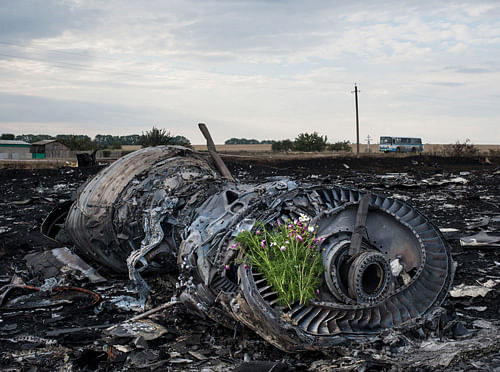 Flowers are placed on a plane engine at the crash site of a Malaysia Airlines jet near the village of Hrabove, eastern Ukraine, Saturday, July 19, 2014. World leaders demanded Friday that pro-Russia rebels who control the eastern Ukraine crash site of Malaysia Airlines Flight 17 give immediate, unfettered access to independent investigators to determine who shot down the plane. AP Photo