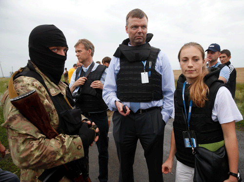 Organisation for Security and Cooperation in Europe (OSCE) monitors speak with a pro-Russian separatist at the crash site of Malaysia Airlines flight MH17, near the settlement of Grabovo in the Donetsk region. Reuters photo