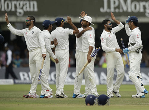 Ravindra Jadeja, second right, celebrates with his teammates including captain and wicketkeeper Mahendra Singh Dhoni, right, after running out England's James Anderson to win the test match on the fifth day of the second cricket test match between England and India at Lord's cricket ground in London, Monday, July 21, 2014. AP photo