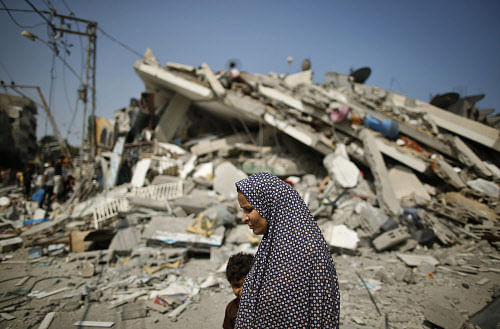 A Palestinian woman walks past the rubble of a residential building, which police said was destroyed in an Israeli air strike, in Gaza City July 22, 2014. Israel kept up its assaults in the Gaza Strip on Tuesday, killing three Palestinians in as many air strikes, as U.S. Secretary of State John Kerry arrived in the region with a mission to seek a ceasefire in the 14-day-old conflict 'as soon as possible.' The deaths in Khan Younis, Beit Hanoun and Beit Lahiya raised the Palestinian toll to 539 killed, including nearly 100 children and many other civilians, since the offensive was launched on July 8, Gaza health officials said. Israel's death toll also rose to 29, with two soldiers killed in the past day of fighting, the Israeli military said. The total includes two civilians killed by rocket fire. REUTERS