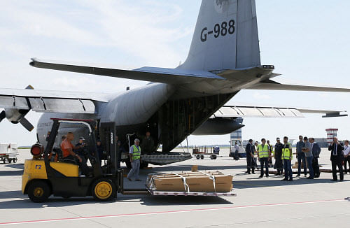 A worker uses a forklift to load coffins containing some of the remains of the victims of Malaysia Airlines MH17 downed over rebel-held territory in eastern Ukraine on to a transport plane before they head to the Netherlands at Kharkiv airport July 23, 2014. REUTERS