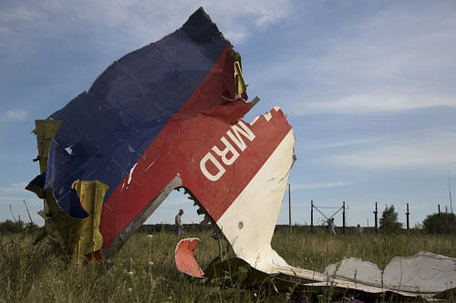 A man walks past a piece of the crashed Malaysia Airlines Flight 17 near the village of Hrabove, eastern Ukraine. AP photo