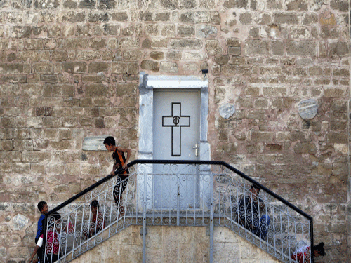 Palestinian boys play on the grounds of the St. Porphyrios Church in Gaza City. For Gaza resident Mahmud Khalaf, it was a bizarre new experience, prostrating himself for his daily Muslim prayers beneath the gaze of an icon of Jesus Christ. AP photo
